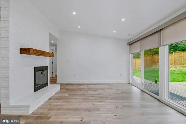 a view of an empty room with a fireplace and a window