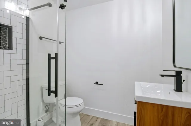 a bathroom with a sink a toilet and shower