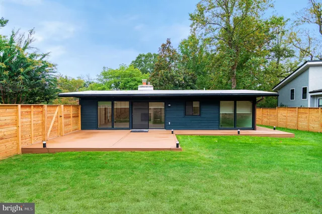 a front view of a house with a yard and trees