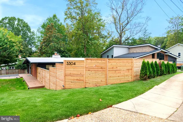 a front view of a house with a yard and trees
