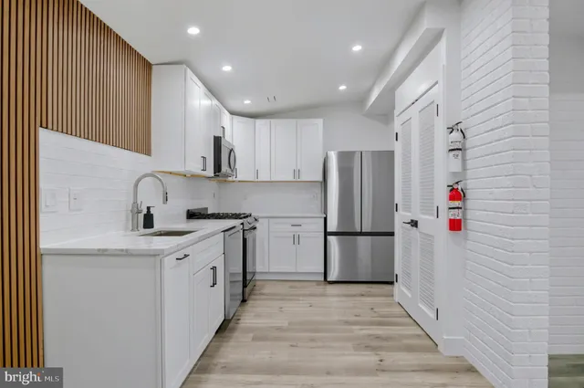 a kitchen with a sink a refrigerator and cabinets