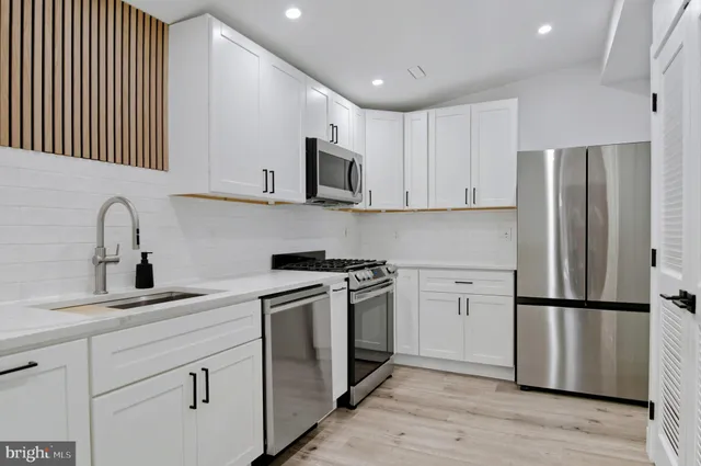 a kitchen with stainless steel appliances granite countertop a refrigerator sink and cabinets
