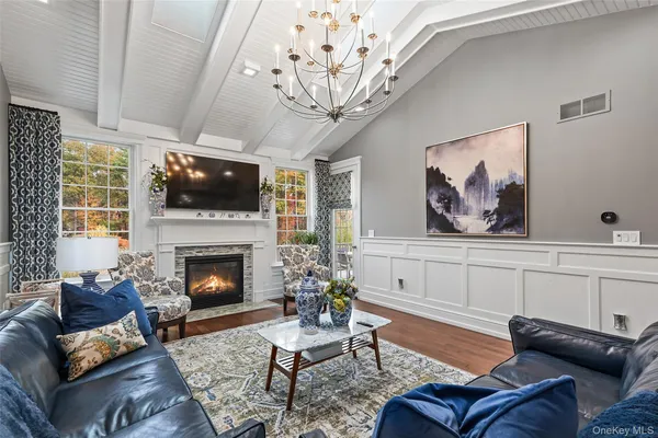 a living room with furniture a fireplace and a flat screen tv