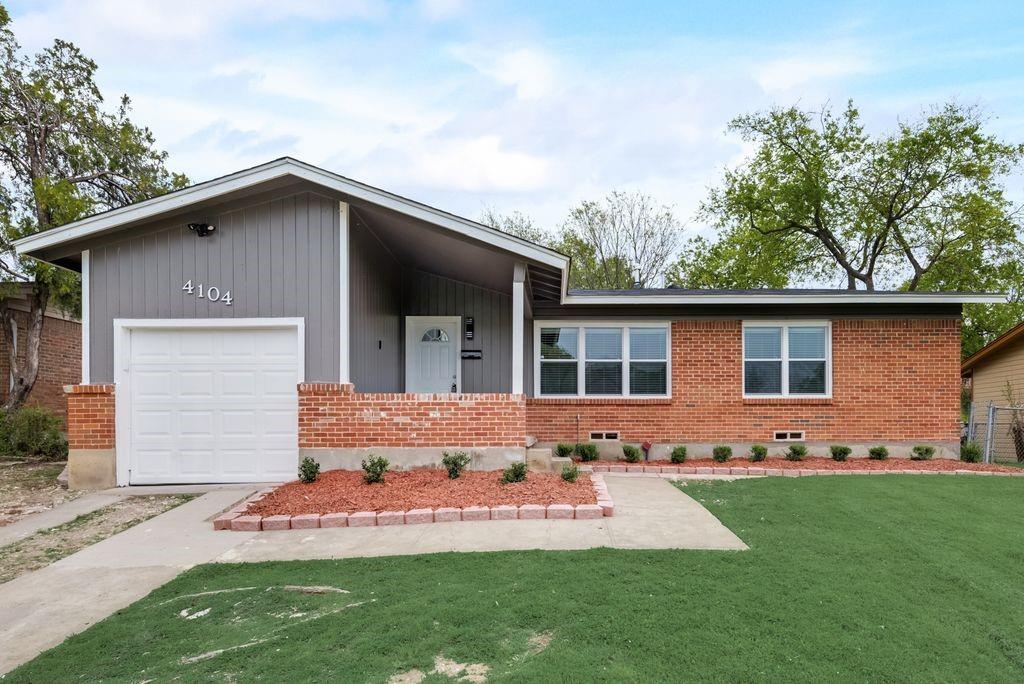 a front view of a house with a garden and yard