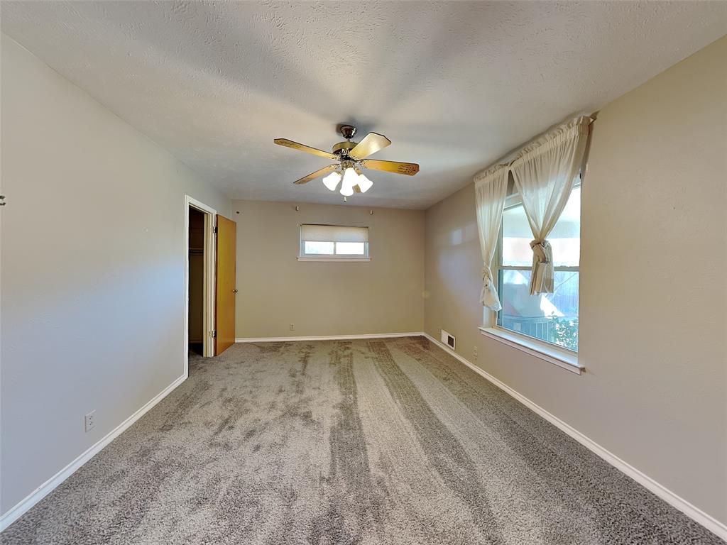 13630 Willow Bend Road Dallas, TX 75240 - Photo 13 of 17 an empty room with windows and chandelier fan