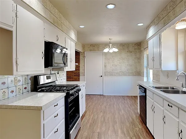 a kitchen with granite countertop a stove and a sink