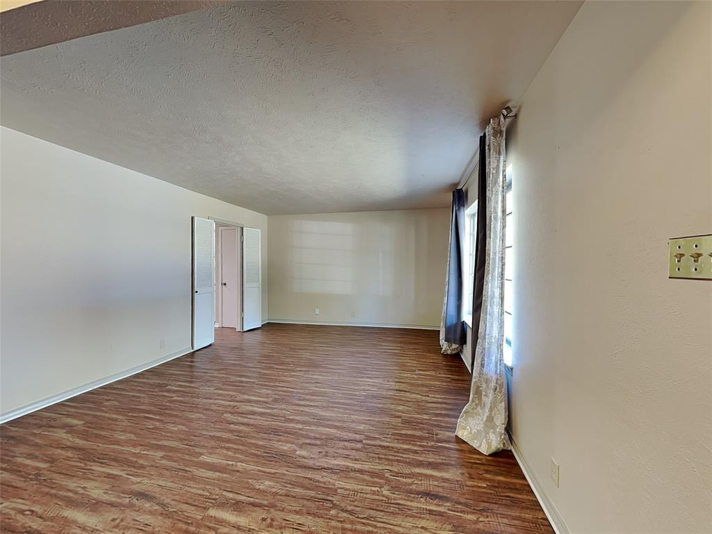 13630 Willow Bend Road Dallas, TX 75240 - Photo 7 of 17 a view of a room with wooden floor and a hallway