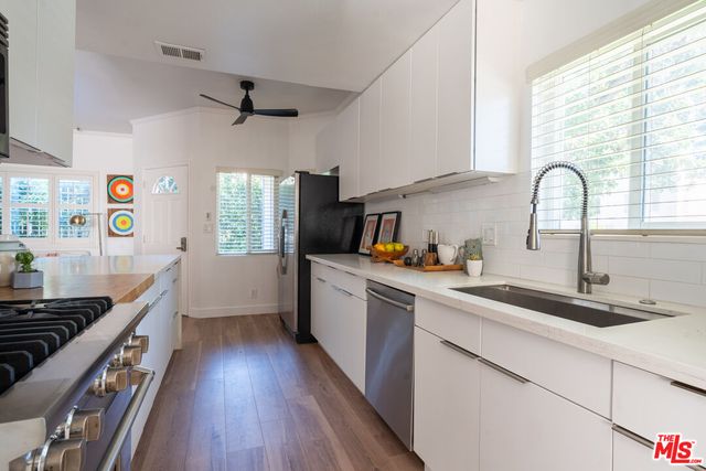 a kitchen with sink a stove and wooden floor