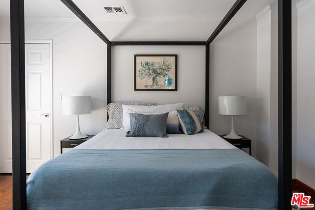 a bedroom with a bed and a painting on the wall