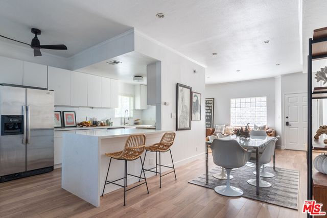 a kitchen with a dining table chairs refrigerator and cabinets