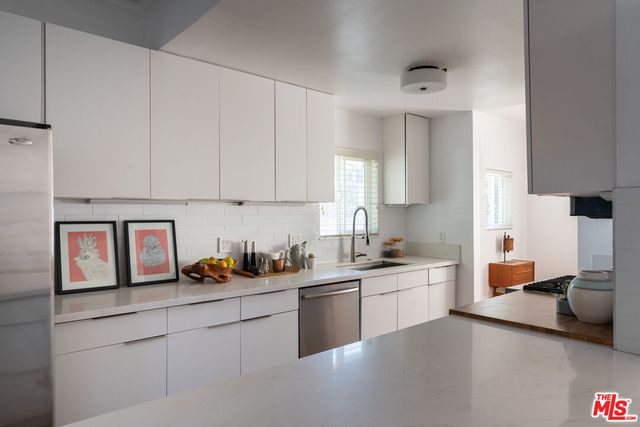 a kitchen with stainless steel appliances a sink stove and cabinets