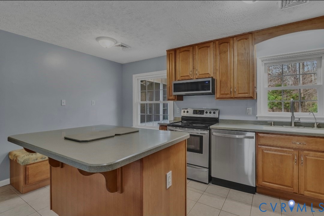 9829 Line Fence Road Hayes, VA 23072 - Photo 10 of 64 a kitchen with stainless steel appliances granite countertop a sink stove and cabinets
