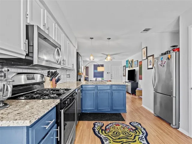 a kitchen with stainless steel appliances granite countertop a stove a refrigerator and a wooden cabinets