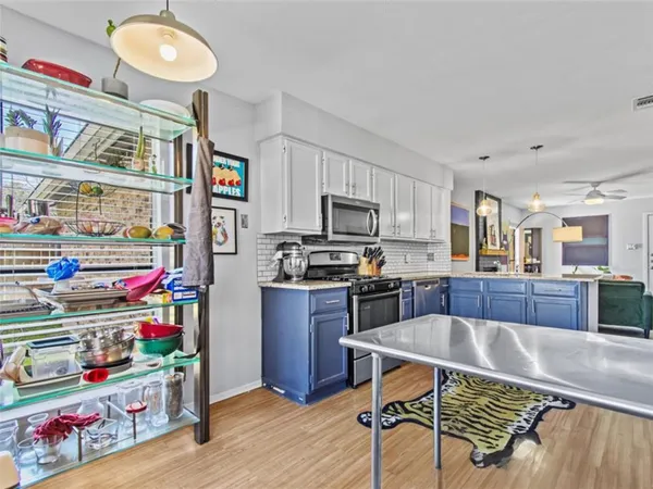 a kitchen with stainless steel appliances granite countertop a sink dishwasher and cabinets with wooden floor