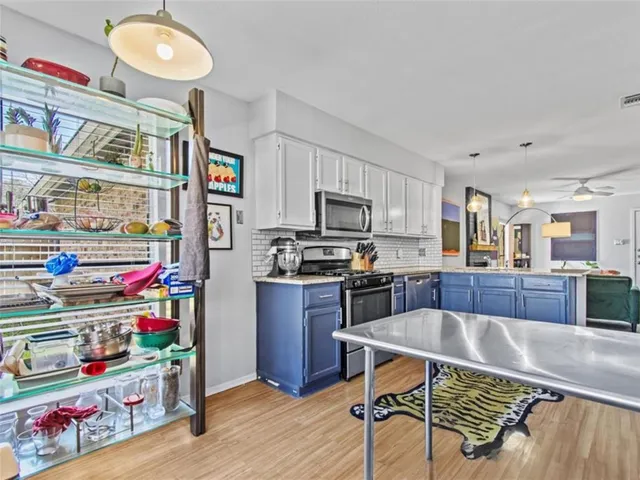 a kitchen with stainless steel appliances granite countertop a sink dishwasher and cabinets with wooden floor