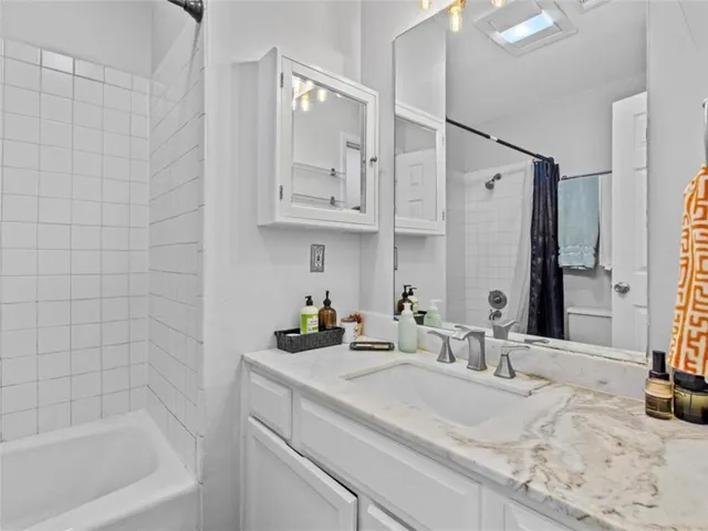 a bathroom with a bathtub sink and mirror