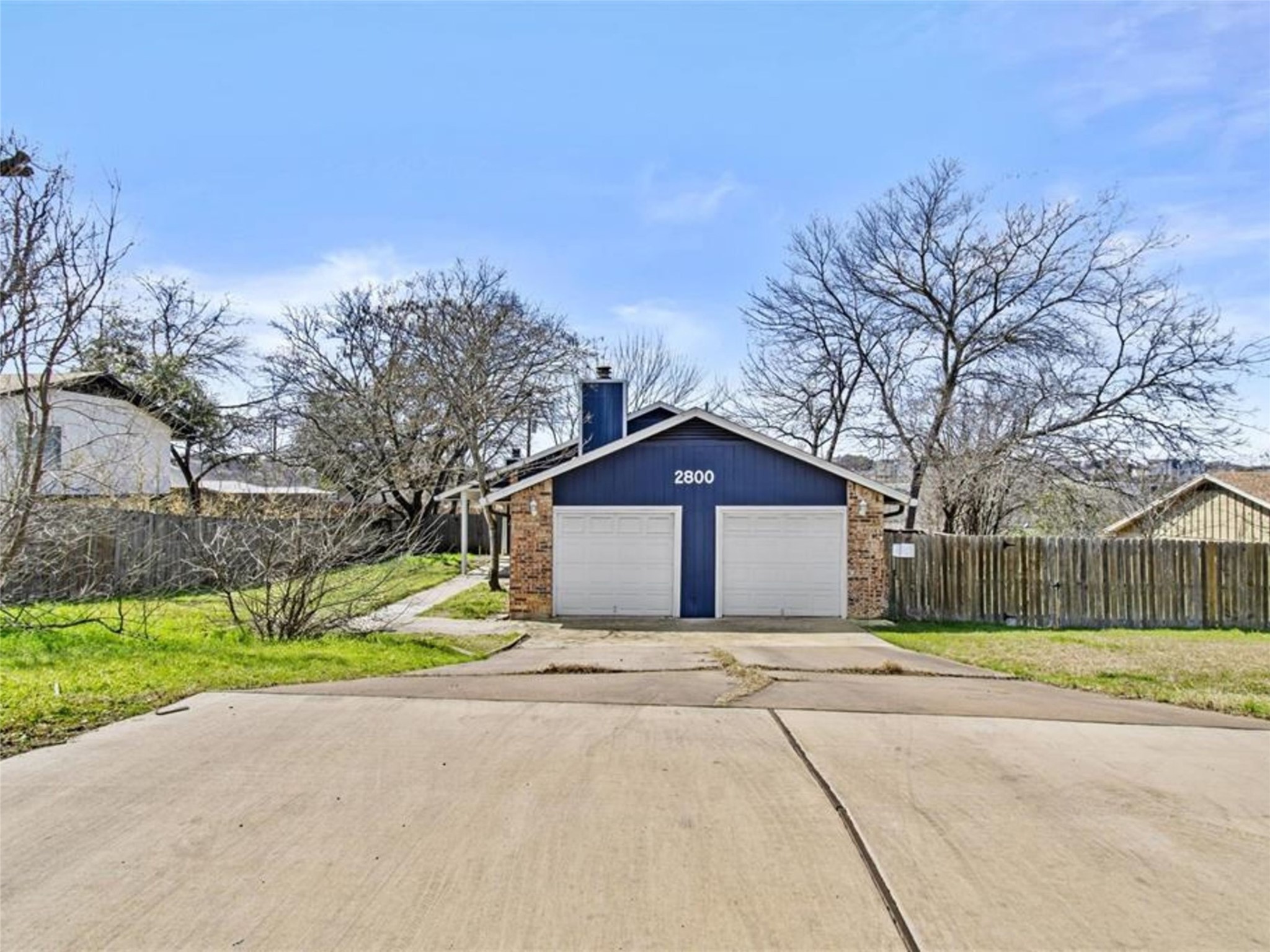 2800 Burleson Road Austin, TX 78741 - Photo 2 of 35 a front view of a house with a yard and garage