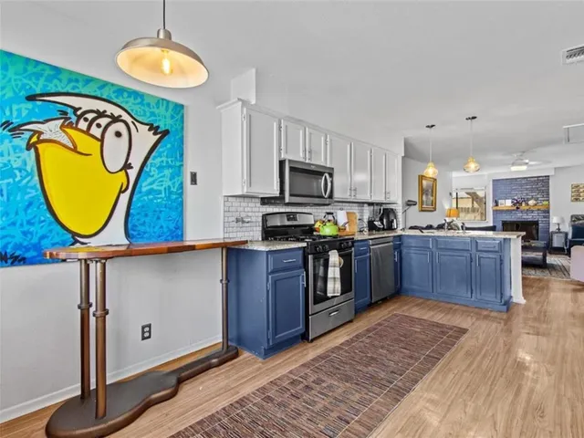 a kitchen with kitchen island granite countertop wooden cabinets stainless steel appliances and a counter space