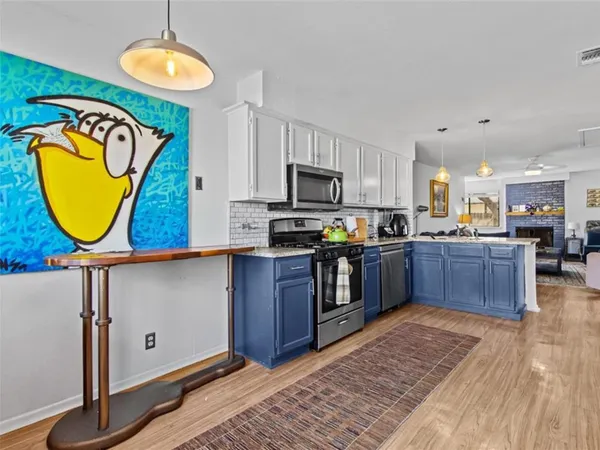 a kitchen with kitchen island granite countertop wooden cabinets stainless steel appliances and a counter space