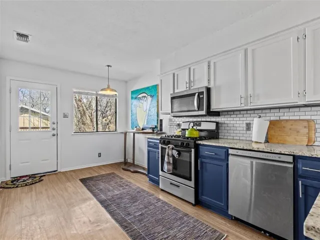 a kitchen with stainless steel appliances granite countertop a stove a sink and a granite counter tops