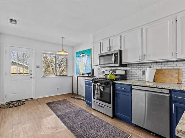 a kitchen with stainless steel appliances granite countertop a stove a sink and a granite counter tops