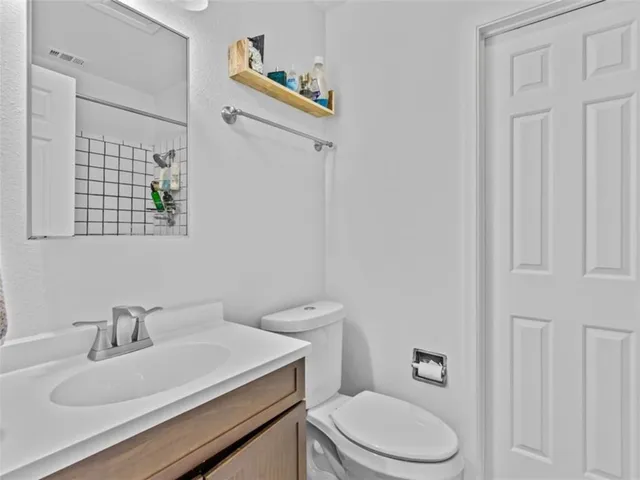 a bathroom with a sink a toilet and a mirror