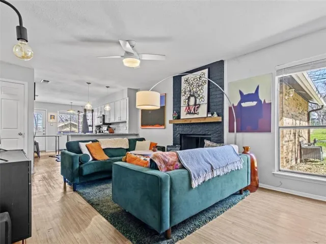 a living room with fireplace furniture and a large window
