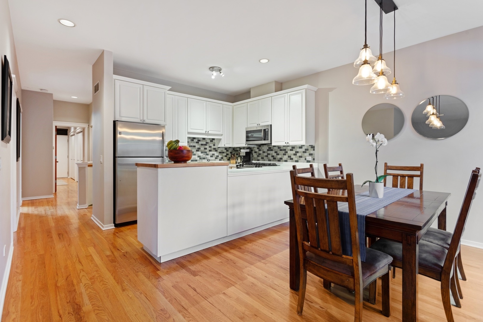 2955 North Racine Avenue, Unit 1A Chicago, IL 60657 - Photo 4 of 29 a kitchen with stainless steel appliances kitchen island granite countertop a table chairs and a refrigerator