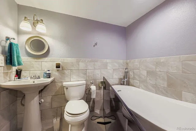 a bathroom with a sink a toilet and a mirror