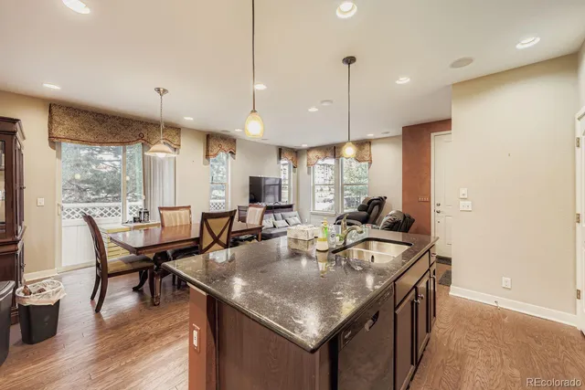 a kitchen with granite countertop a table chairs stove a refrigerator and cabinets
