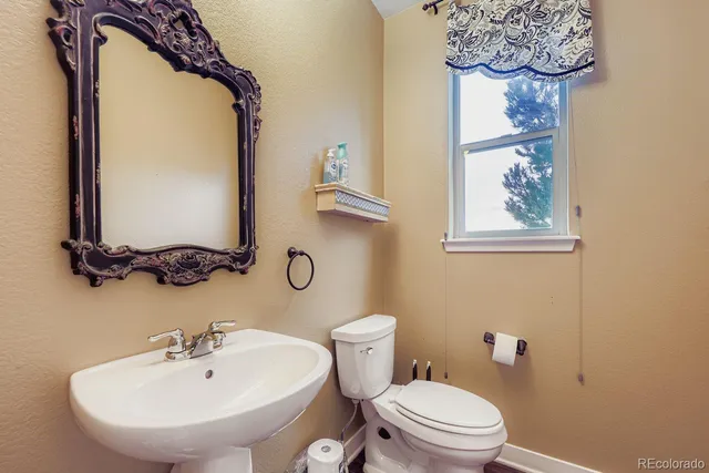 a bathroom with a toilet a sink and mirror
