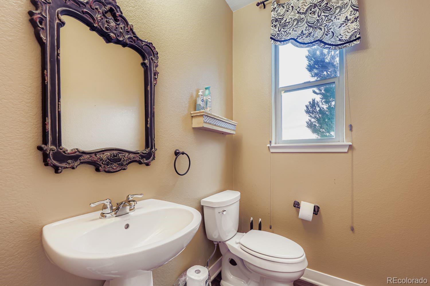 8508 Redpoint Way Broomfield, CO 80021 - Photo 7 of 21 a bathroom with a toilet a sink and mirror