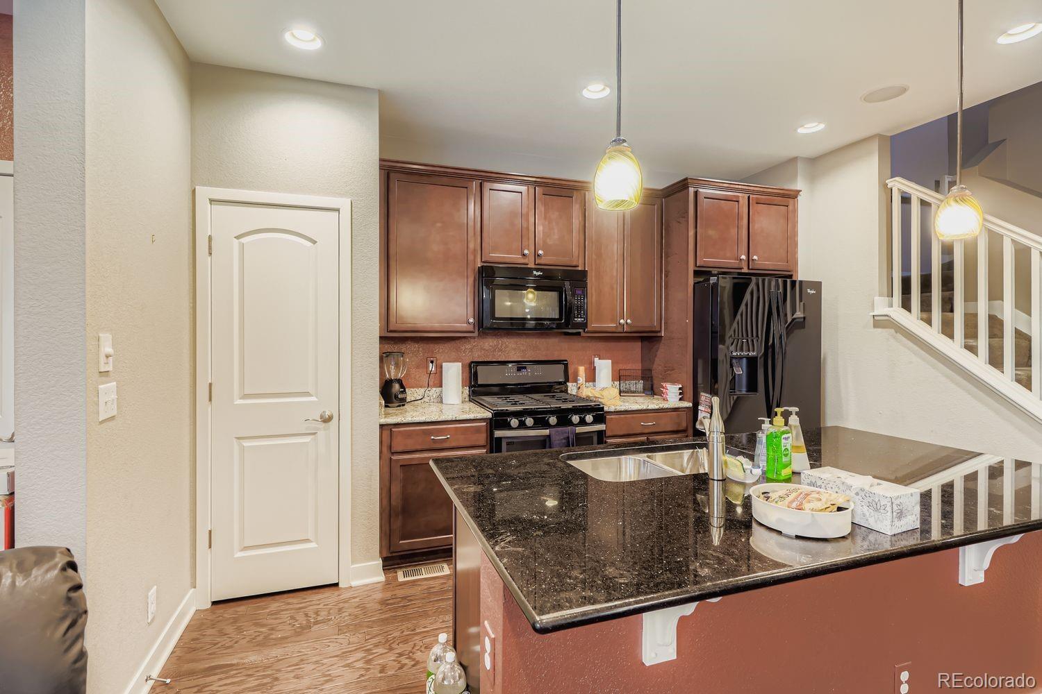 8508 Redpoint Way Broomfield, CO 80021 - Photo 9 of 21 a kitchen with stainless steel appliances granite countertop a refrigerator a stove top oven a sink and a refrigerator