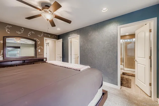 a spacious bedroom with a large bed and a chandelier