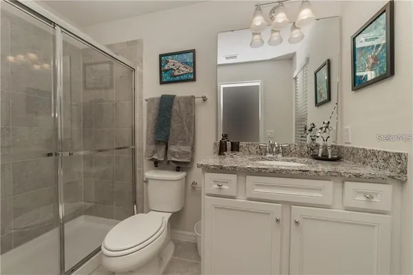 a bathroom with a granite countertop toilet sink and shower