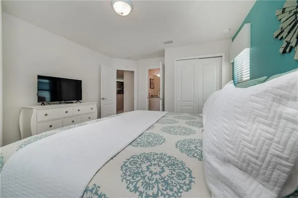 a bedroom with a flat screen tv and a bed