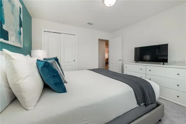 a bedroom with a bed and a flat screen tv