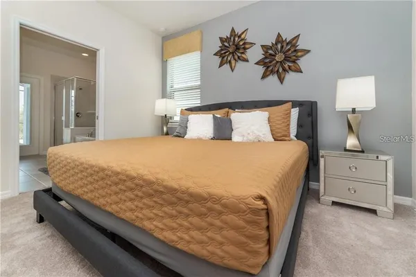 a bed sitting in a bedroom and lamp