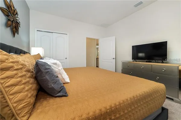 a bedroom with a bed and a flat screen tv