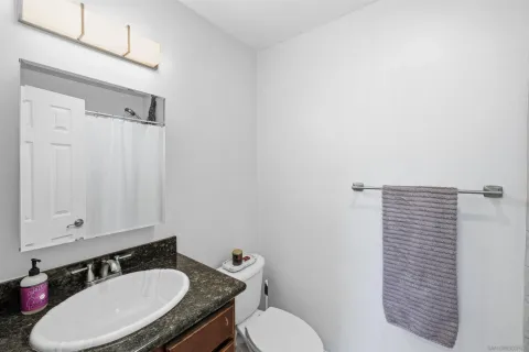 a bathroom with a granite countertop sink and a mirror