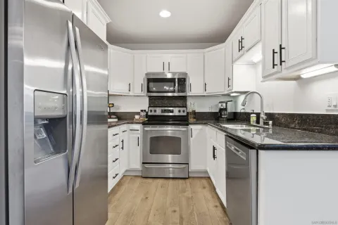 a kitchen with stainless steel appliances granite countertop a stove a refrigerator and a sink