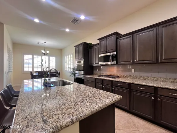 a kitchen with granite countertop a refrigerator and a sink