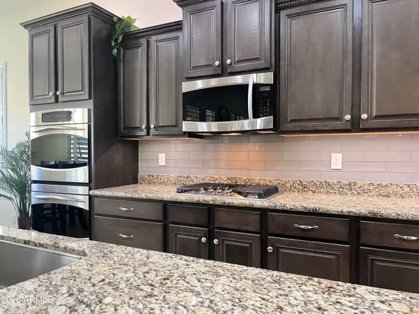 a kitchen with a sink a counter space appliances and cabinets