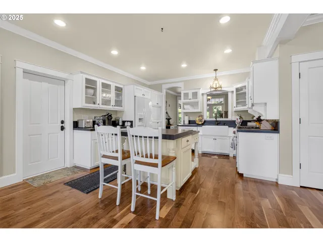 a kitchen with stainless steel appliances kitchen island granite countertop a refrigerator and cabinets