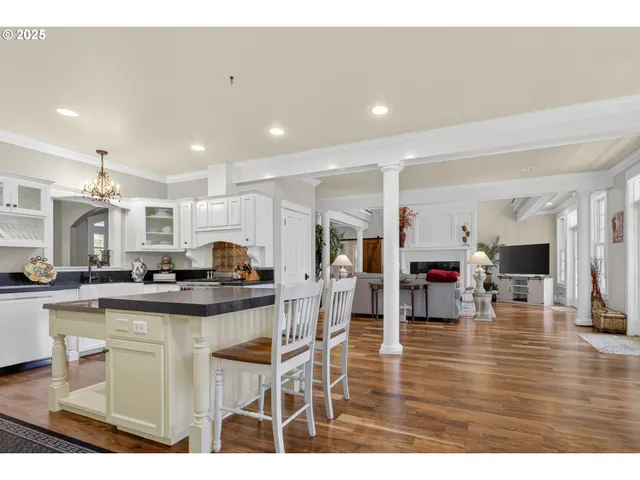 a kitchen with stainless steel appliances kitchen island granite countertop a stove and white cabinets