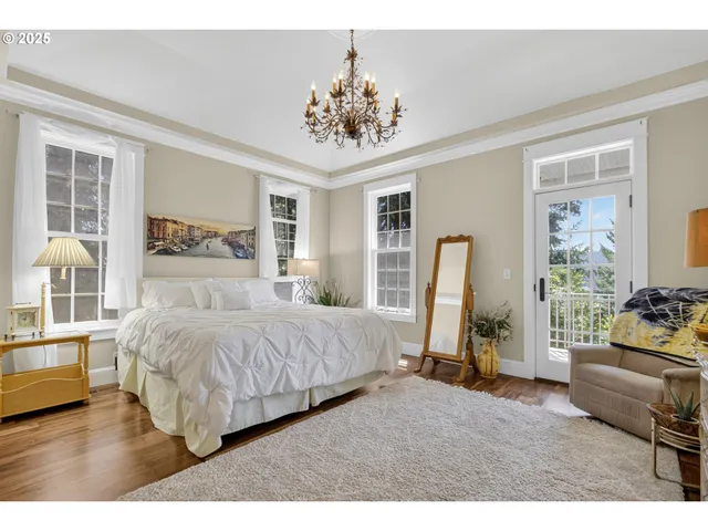 a bedroom with a bed and large windows