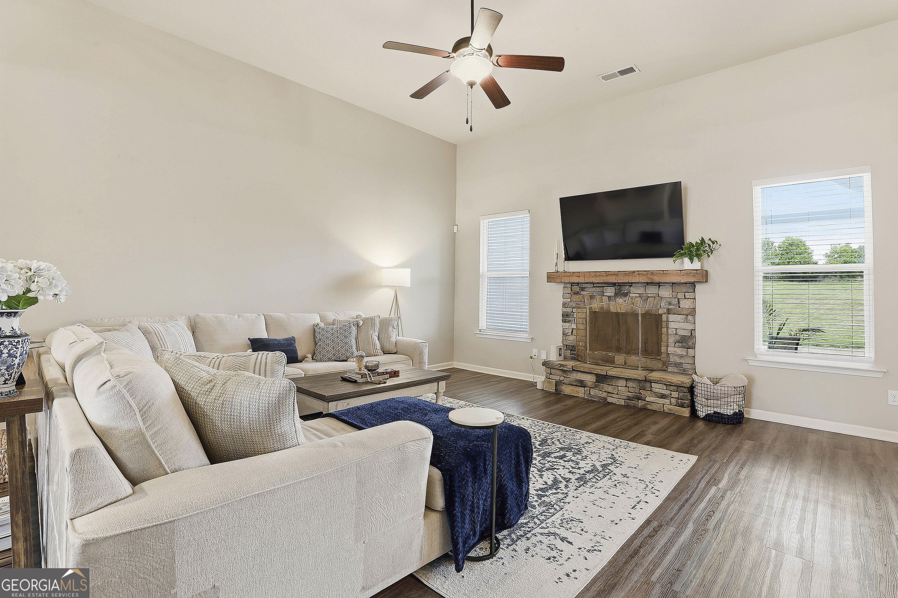 66 Chapman Farm Road Senoia, GA 30276 - Photo 14 of 46 a living room with furniture a flat screen tv and a fireplace