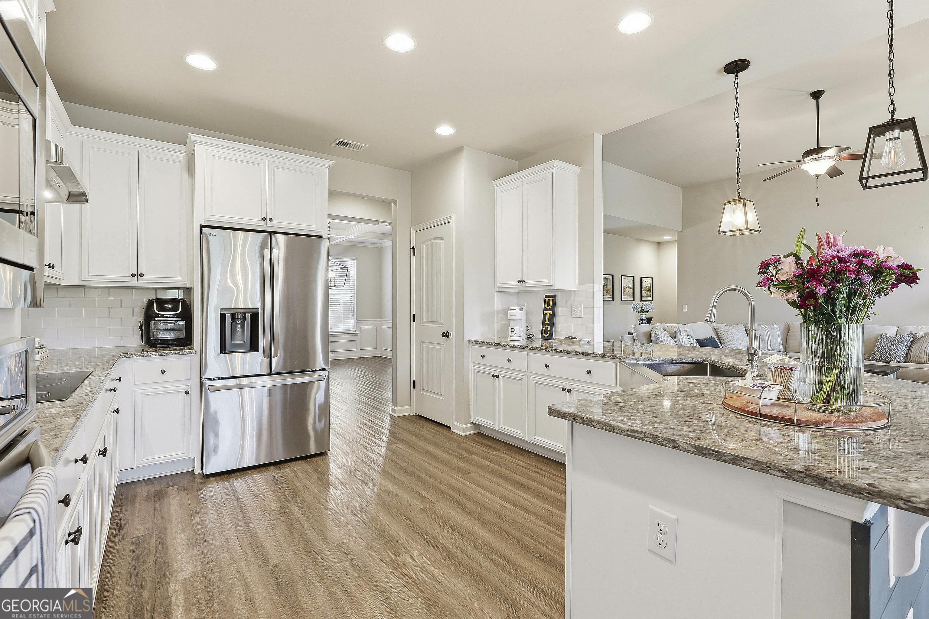 66 Chapman Farm Road Senoia, GA 30276 - Photo 21 of 46 a kitchen with stainless steel appliances kitchen island granite countertop a refrigerator a sink dishwasher and white cabinets with wooden floor