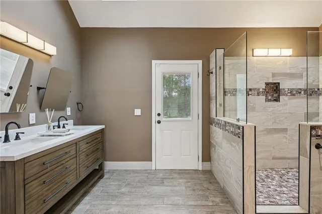a bathroom with a sink a mirror a vanity and a shower