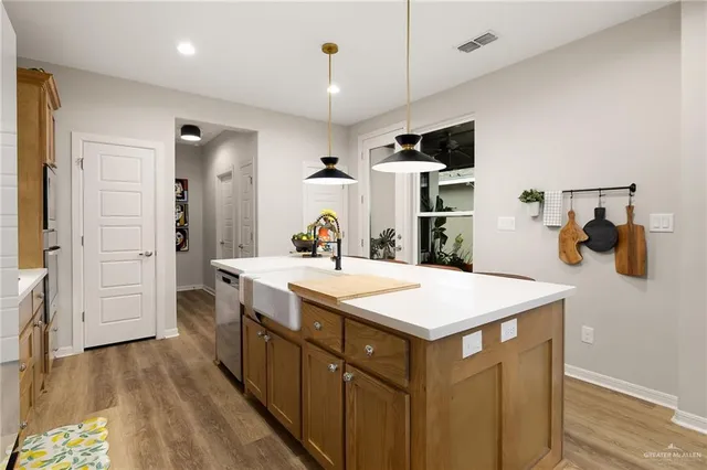 a kitchen with a sink a counter top space and stainless steel appliances